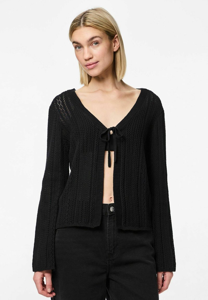 Svart stickad cardigan med öppen framsida, V-ringning och knytstängning. Har långa ärmar, ribbade muddar och texturerad tyg.