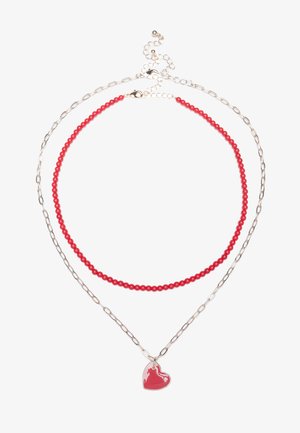 Red beaded necklace layered with a silver link chain, featuring a glossy red heart pendant. Overall lightweight with a simple design.