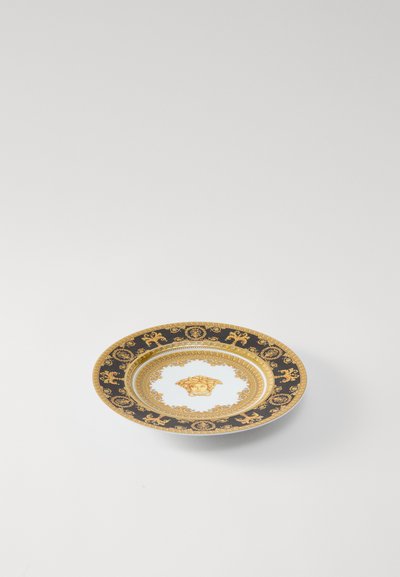 Čierny a zlatý dekoratívny tanier s centrálnym motívom hlavy leva, zdobenými vzormi a hladkým bielym vnútorným povrchom.