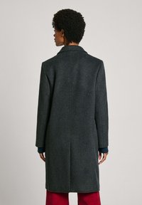 Manteau gris foncé en mélange de laine, avec un col cranté, des manches longues et une silhouette droite au tissu lisse.
