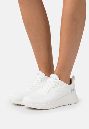White athletic shoes made of breathable mesh, featuring a textured surface, light blue accents, and a cushioned sole for comfort.