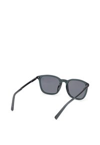 Lunettes de soleil gris foncé avec des verres rectangulaires et des branches fines noires, posées ouvertes sur un fond blanc.