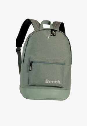 Green fabric backpack with a textured finish, contrasting smooth mint green bottom, front zip pocket, and "Bench." logo. Adjustable straps.