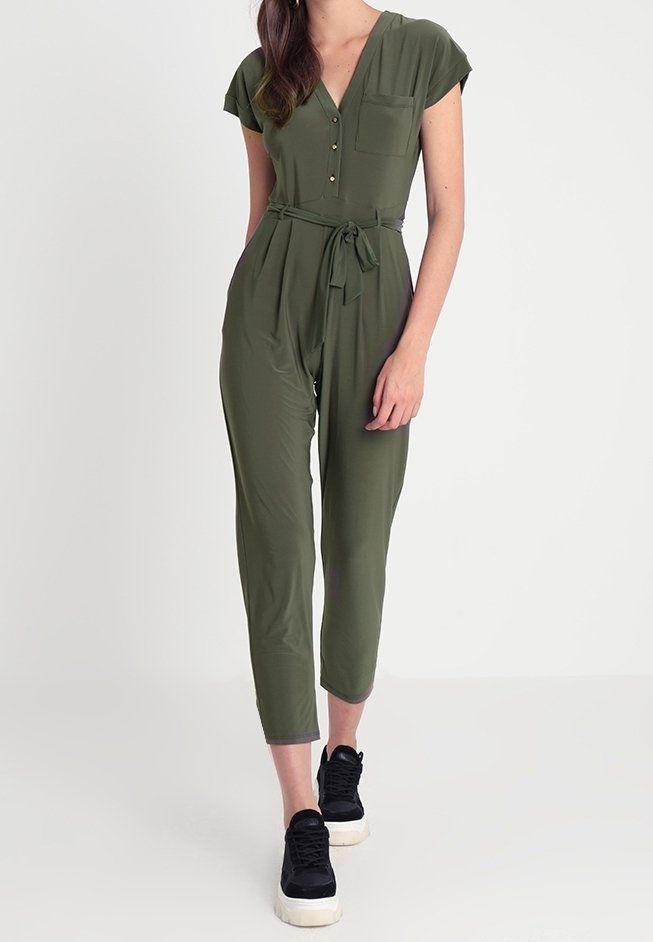 Combinaison vert olive à manches courtes, col en V, boutons sur le devant et ceinture à nouer. Le matériau semble lisse et léger ; coupe longueur cheville.