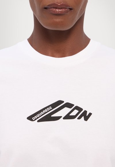 Weißes Baumwoll-T-Shirt mit einem auffälligen schwarzen DSQUARED2-Logo und einem dynamischen Design über der Brust. Weicher Stoff und klassischer Rundhalsausschnitt.