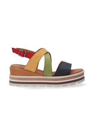 Multicolored platform sandals with cross-straps, featuring yellow, green, red, and navy blue leather. Sturdy sole with striped accents.