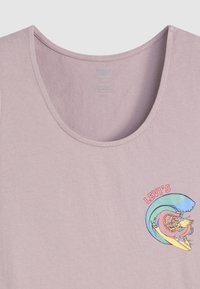 Svijetloplavi top bez rukava s okruglim izrezom, koji ima šareni grafički prikaz zmaja na dasku za surfanje, a uz to je i tekst "LEVI'S" u crvenoj boji.