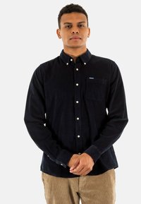 Navyblauw corduroy overhemd met een button-down kraag, een borstzak en witte knopen, met een subtiele logotipo op de borst.
