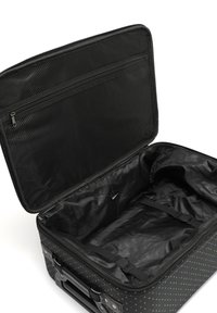 Černý kufr s multibarevnými puntíky, uzávěr na zip, síťová kapsa a vnitřní popruhy pro zajištění věcí. Texturovaný design látky.