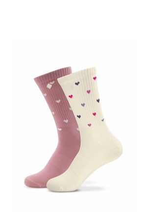 Deux paires de chaussettes côtelées, une rose avec des cœurs blancs et une crème avec des cœurs en rose, violet et bleu, présentées côte à côte.