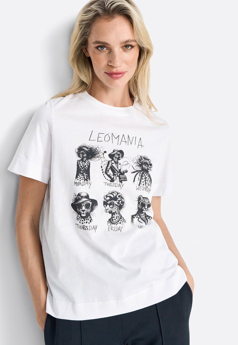 White cotton t-shirt featuring a graphic of stylized, patterned animal illustrations for each day of the week, labeled beneath each design.