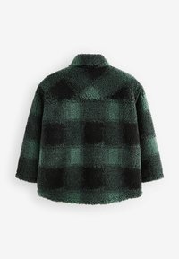 Giacca in pile a quadretti verdi e neri, caratterizzata da un materiale testurizzato e soffice, colletto e una vestibilità rilassata con spalle scese.