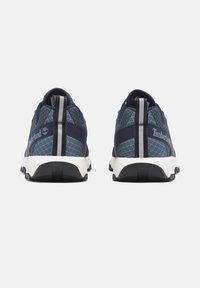 Zapatillas deportivas azul marino con una parte superior de malla texturizada, cuello acolchado y suela blanca en contraste. Presentan un logotipo y detalles reflectantes en la parte trasera.
