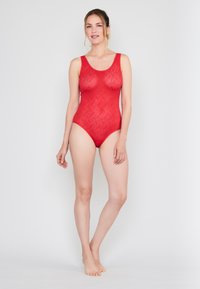 Rødt bodystocking med en bølget struktur, der har en rund halsudskæring og tankstropper, designet med en tætsiddende form. Ingen yderligere detaljer.