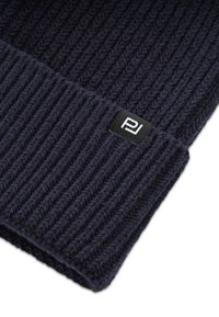 Dziana granatowa czapka beanie z prążkowaną teksturą i podwiniętym mankietem; posiada małą czarną metkę z białym logo "P".