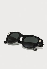 Ochelari de soare negri cu un finisaj lucios, lentile mari ovale, accente aurii cu cristale pe ramă și brațe elegante.