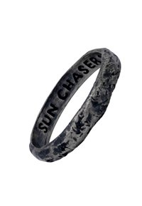 Blackened metal ring with a textured finish, engraved with “SUN CHASER” on the inner band, showcasing a rugged, organic design.