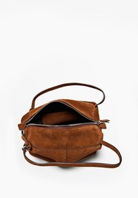 Hnědá semišová taška přes rameno se zipovým uzávěrem, odnímatelným koženým popruhem a vnitřním logem. Měkká textura a strukturovaný tvar.