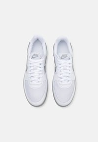 Vita sneakers med en slät överdel i läder och textil, med grå accenter, rund tå och snörning. Nike-logotyp på tungan.