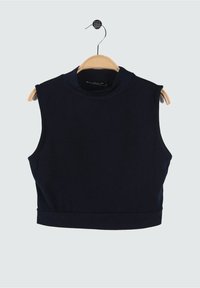 Débardeur court bleu marine en tissu lisse, avec un col montant et sans manches, présenté sur un cintre en bois.