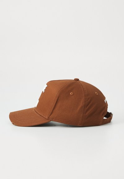Casquette en coton marron avec une visière incurvée, des détails cousus et une sangle Velcro à l'arrière pour un ajustement réglable. L'avant présente des lettres blanches.