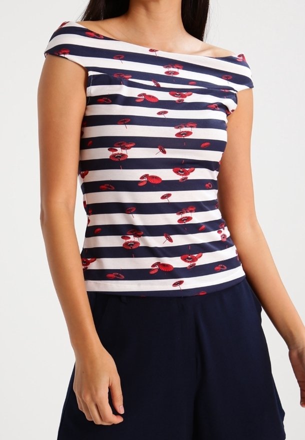Pruhovaný off-shoulder top s námořnickými a bílými pruhy, ozdobený červenými květinovými akcenty. Vyrobeno z elastického materiálu, těsně přiléhající design.