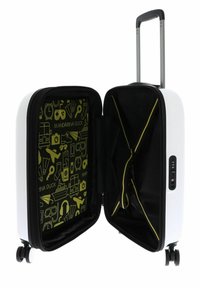 Maleta rígida blanca con interior negro, forro de diseño amarillo, correas interiores y un mango telescópico. Cuenta con cuatro ruedas y un candado de combinación.