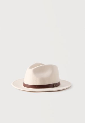 Off-white bredbremmet fedora-hatt med et brunt lærbånd og en liten spenne, vist på en ensfarget hvit bakgrunn.