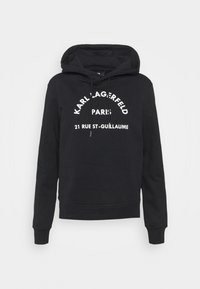 Černá mikina vyrobená z bavlny, s kapucí na šňůrku, ribovými manžetami a předním potiskem v bílé barvě se slovy "Karl Lagerfeld Paris" a adresou.