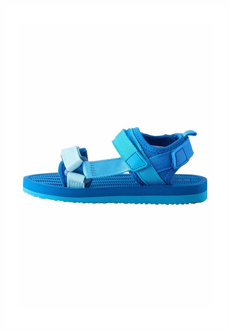 Sandal azul con múltiples tiras en diferentes tonos de azul, plantilla texturizada y cierres de velcro ajustables para un ajuste seguro.