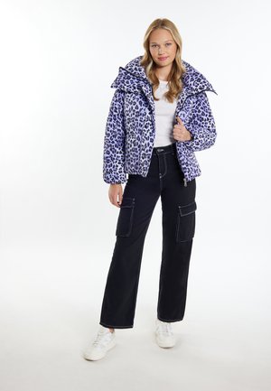 Fioletowa kurtka puchowa w panterkę z dużym kołnierzem, zamek błyskawiczny, dwie przednie kieszenie, połączona z czarnymi spodniami cargo i białymi trampkami.