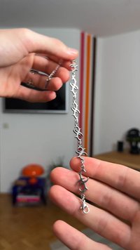 Ασημένιο βραχιόλι αλυσίδας με διασυνδεδεμένα αφηρημένα σχήματα, ομαλή υφή και κούμπωμα τύπου αστακού για ασφαλές κλείσιμο.