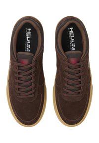 Bruna mockaskinnssneakers med rund tå och gummisula. Utrustad med röda detaljer på snörning och logotyp, samt en strukturerad svart foder.