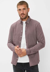 Bordeaux lange mouwen shirt met een button-down kraag, gestructureerde stof en witte knopen, gelaagd over een wit t-shirt, gecombineerd met donkere jeans.