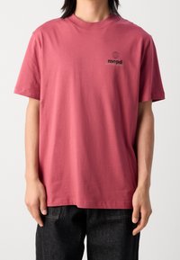 Camiseta de manga corta en algodón rosa apagado, con cuello redondo y estampado de logo negro en el lado izquierdo del pecho, con un corte relajado.