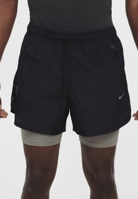 Čierne šortky Nike vyrobené z ľahkej, zvráskavenej tkaniny. Obsahujú elastický pás, šnúrku na stiahnutie a bočné vrecká.