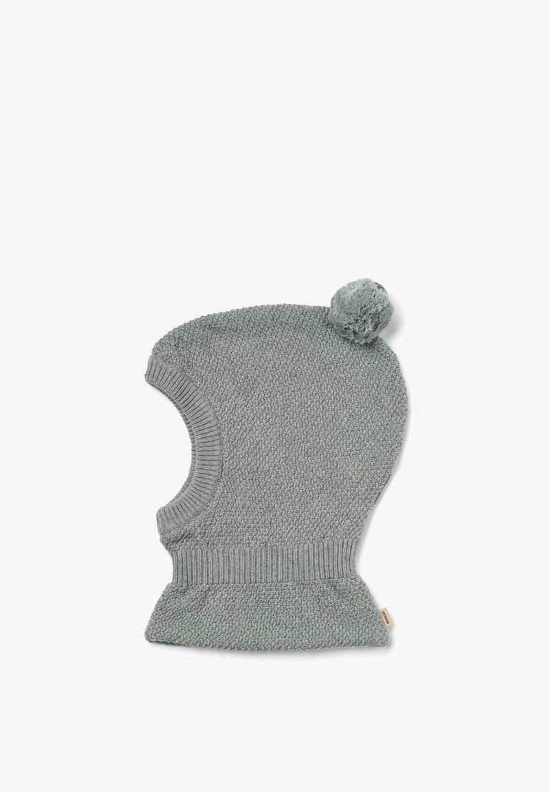 Cagoule tricotée en gris clair avec un pompon rond sur le dessus et des bords côtelés, présentant un motif texturé lisse sur l'ensemble.