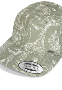 Gorra ajustable con una tela texturizada de color verde claro con patrones abstractos blancos y una etiqueta plateada que dice "The Authentic Yupoong Since 1974."