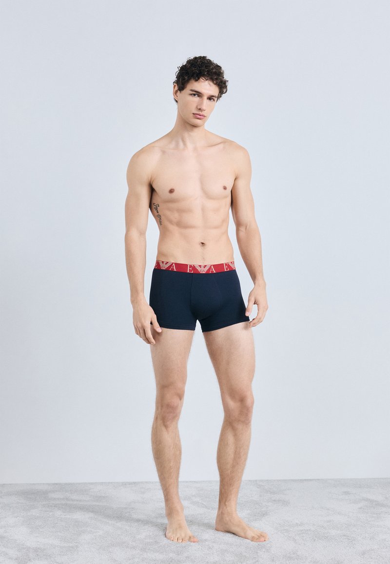 Cuecas boxer azul-marinho com cintura vermelha com marca, material de mistura de algodão, design ajustado ao corpo e textura suave.