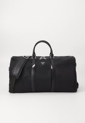 Schwarze Stoff-Transporttasche mit Lederakzenten, zwei oberen Griffen und einem abnehmbaren Schulterriemen. Verfügt über einen Reißverschluss und ein Logo-Detail.