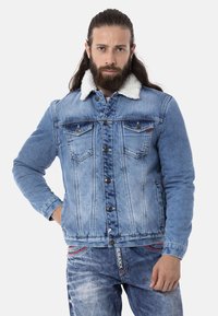 Jeansjacke mit einer hellblauen Waschung, Sherpa-Kragen, Knopfleiste und zwei Brusttaschen. Strukturiertes Material mit einer figurbetonten Passform.