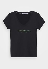 Black cotton t-shirt with a v-neck, featuring reflective text "CALVIN KLEIN JEANS NEW YORK" on the front and a small logo on the sleeve.