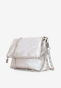 Bolso de mano metálico plateado con solapa plegable, que incluye un bolsillo con cremallera, cadena para el hombro y textura suave.