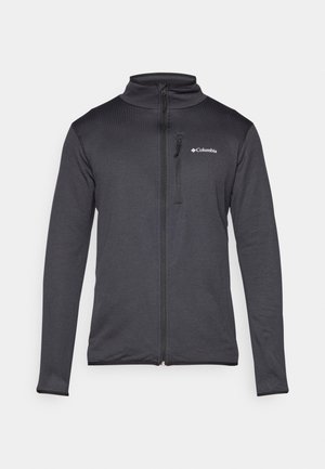 Črna zip-up jakna iz teksturiranega blaga. Ima visok ovratnik in dolge rokave z žepom na zadrgo na levem prsnem delu.