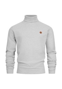 Suéter de cuello alto gris hecho de un material suave y acanalado. Presenta mangas largas y un pequeño parche de logo de cuero marrón en el pecho.