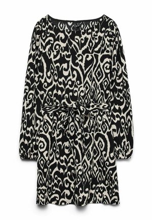 Langærmet sort og hvid kjole med abstrakte swirl- og diamantmønstre, med et bundet stofbælte i taljen.