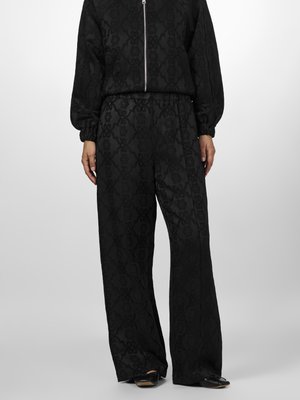 Black zip-up jacket and wide-leg pants set, featuring a textured geometric pattern, elastic waistband, and cuffed sleeves. Smooth material.