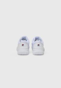 Zapatillas deportivas blancas con una suela de goma texturizada, parte superior de malla, cuello acolchado y un pequeño logotipo en la parte posterior. Diseño simple, sin patrones visibles.
