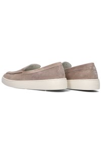 Tan suede instappers met een gladde textuur, laag profiel, ronde neus en witte rubberen zool. Beschikt over subtiele stikdetails aan de zijkanten.