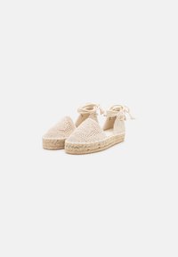 Espadrillas beige all'uncinetto con punta triangolare, legate alla caviglia, dotate di suola in juta e tomaia texture.